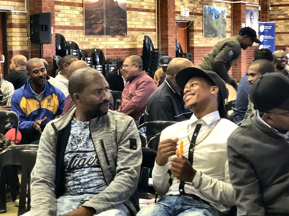 A seated audience laughing during a HappiSpace session