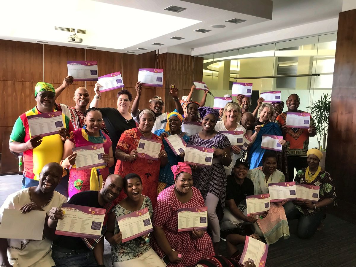 A group holding their certificates after a session